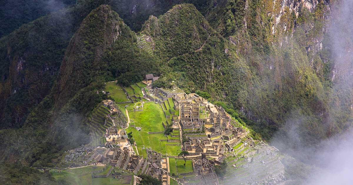 Mist frames the Machu Picchu ruins seen from the Machu Picchu Mountain hike. Photo by Daniella Beccaria.