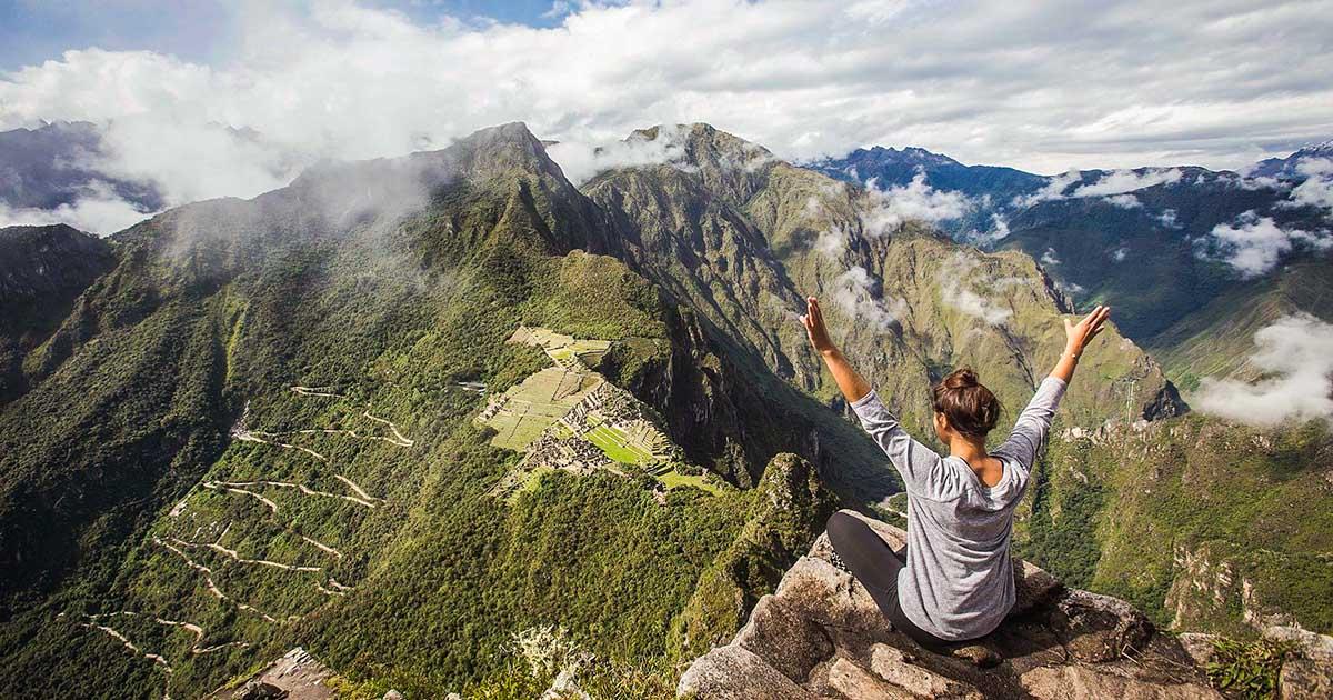 A visitor celebrates reaching the Huayna Picchu viewpoint. Photo by Peru For Less