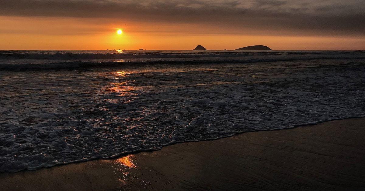 Sun setting over a beach on the Peruvian coast. Photo by Valeria Romero on Unsplash.