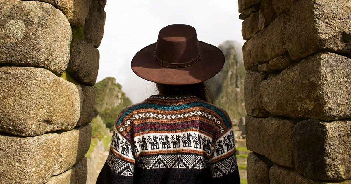 A woman looking through a doorway at Machu Picchu. Photo by Jeison Higuita on Unsplash.