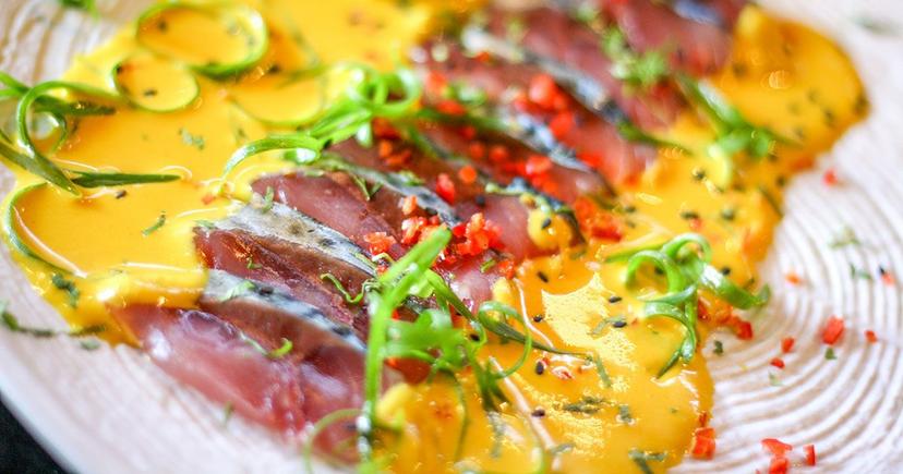 <div class="entry-thumb-caption">A Nikkei dish with bright yellow sauce, red peppers, and green garnishes. Photo by <a class="text-secondary" href="https://www.peruforless.com/">Peru For Less</a>
</div>