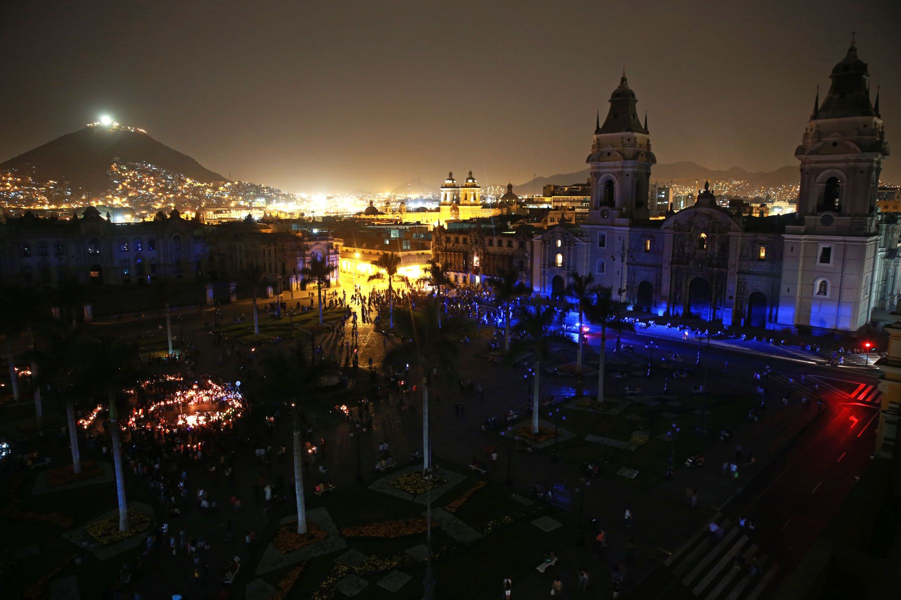 Lights out in Plaza Mayor of Lima. Semi-aerial show with hill in the distance to the left.