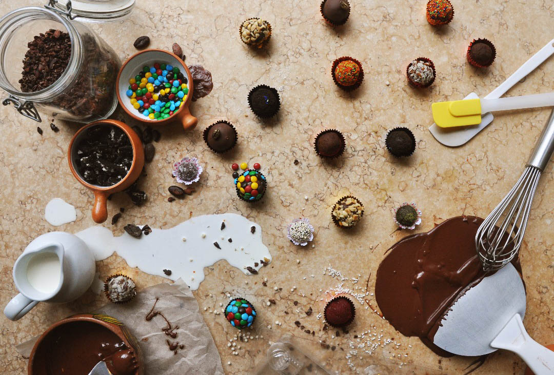 Truffles, varied ingredients and melted chocolate scattered artfully on a table at ChocoMuseo