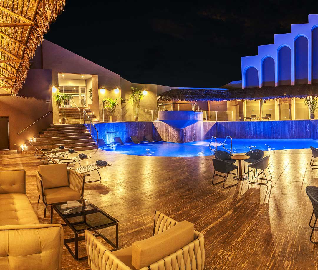 The rooftop pool area at the DoubleTree by Hilton hotel in Iquitos, Peru lit up at night.