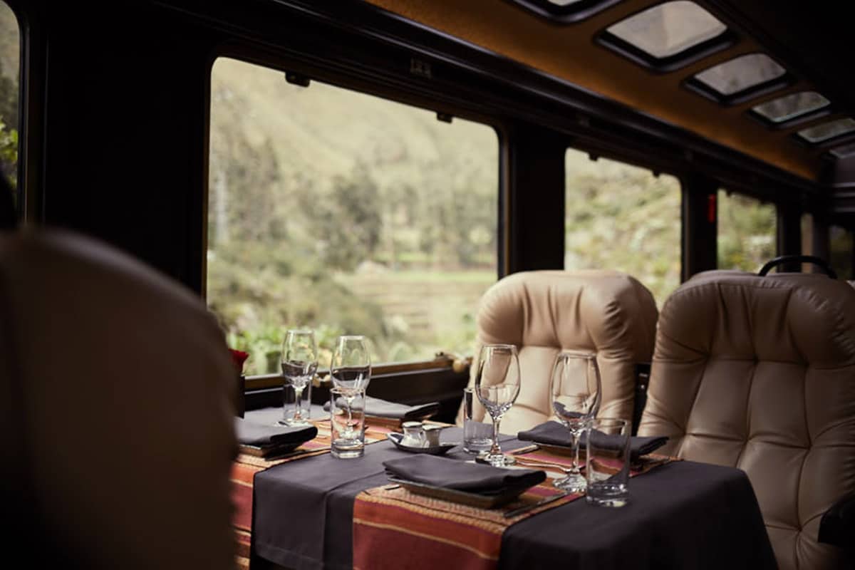 The inside of the Inca Rail First-Class Train to Machu Picchu with a table set for a gourmet meal.