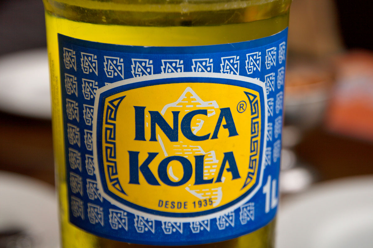 A close up of the blue and white label of Inca Kola.