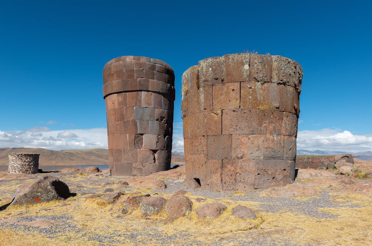 Two Inca funerary towers of Sillustani, Peru with a blue sky in the background.