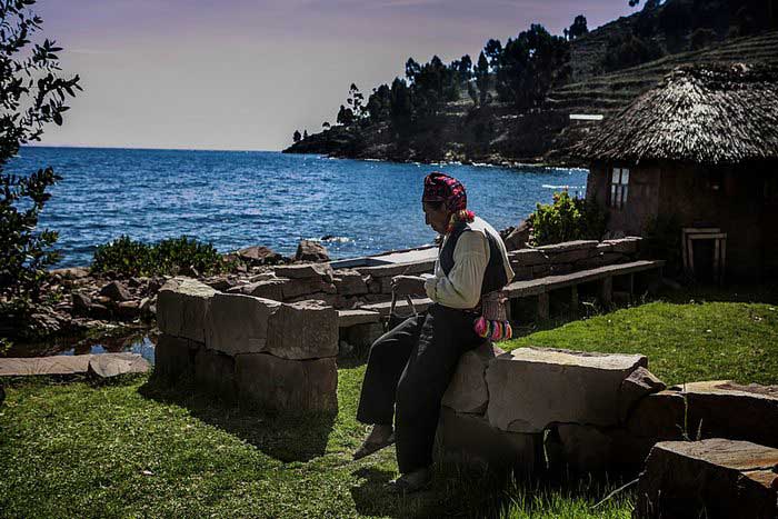 A man from the Island of Taquile weaving a piece of cloth, Lake Titicaca