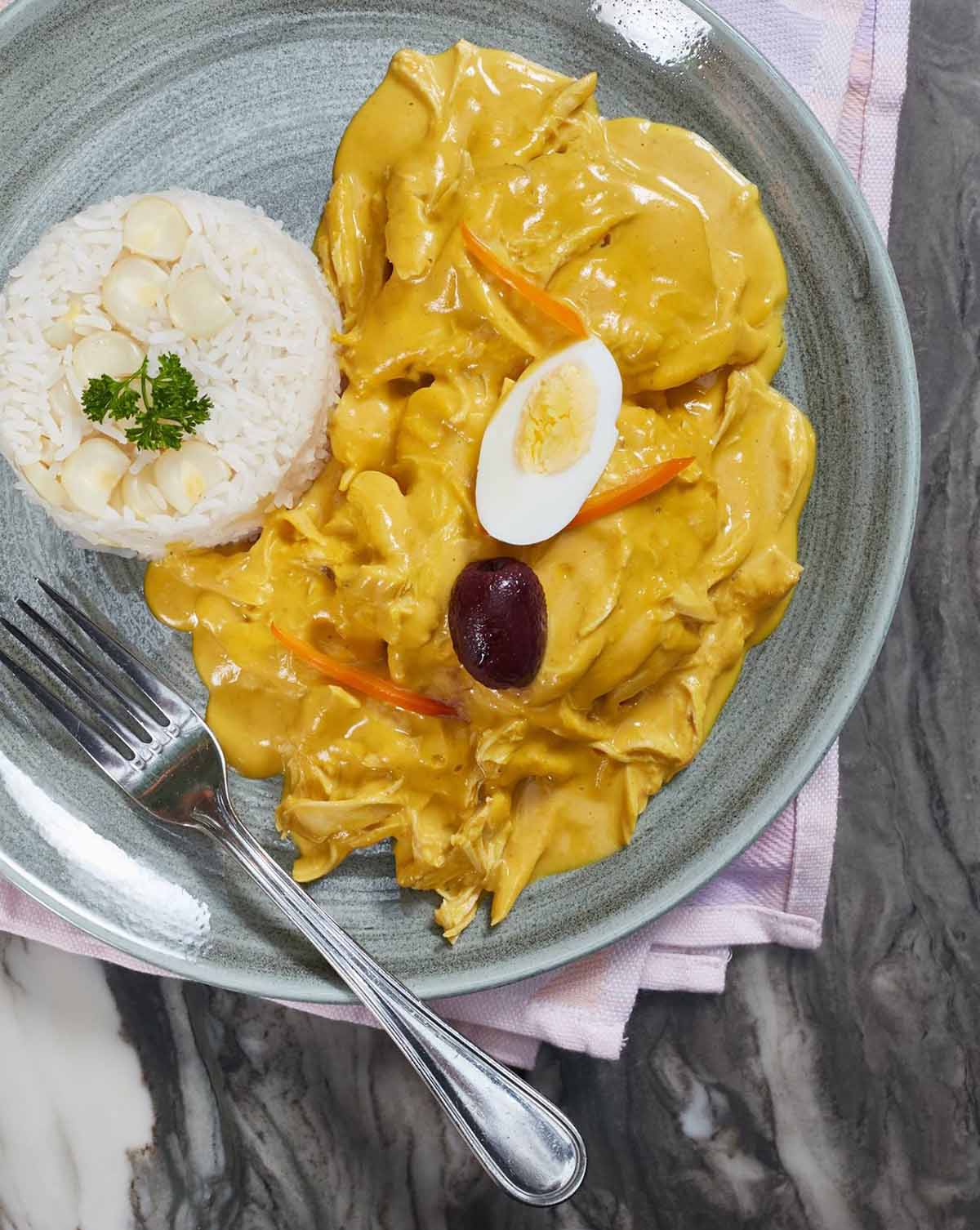 A top Peruvian food, aji de gallina is a yellow chicken stew served with white rice.