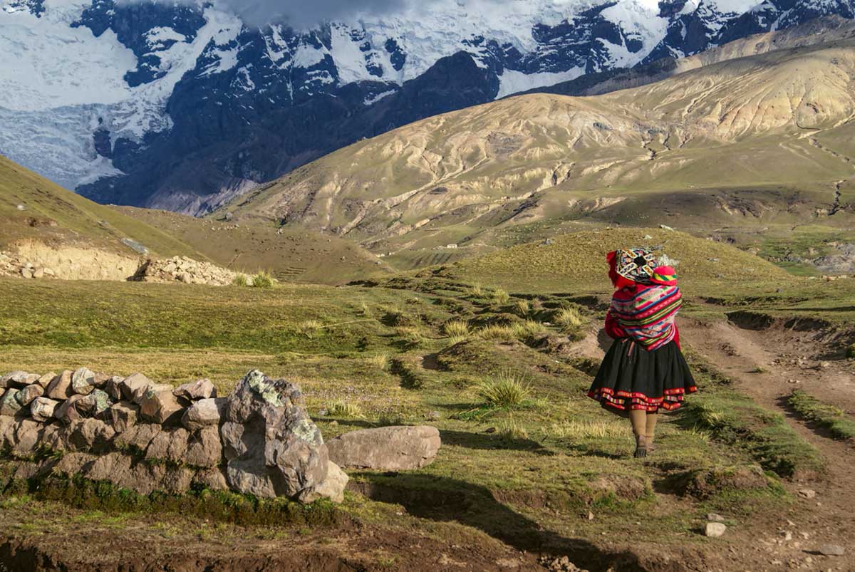 Woman in traditional Andean attire walking the in the Andes Mountains