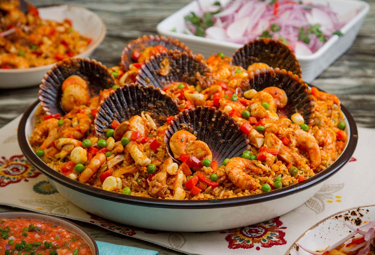 A bowl of arroz con mariscos with rice, peas, red pepper, and seafood, similar to paella.