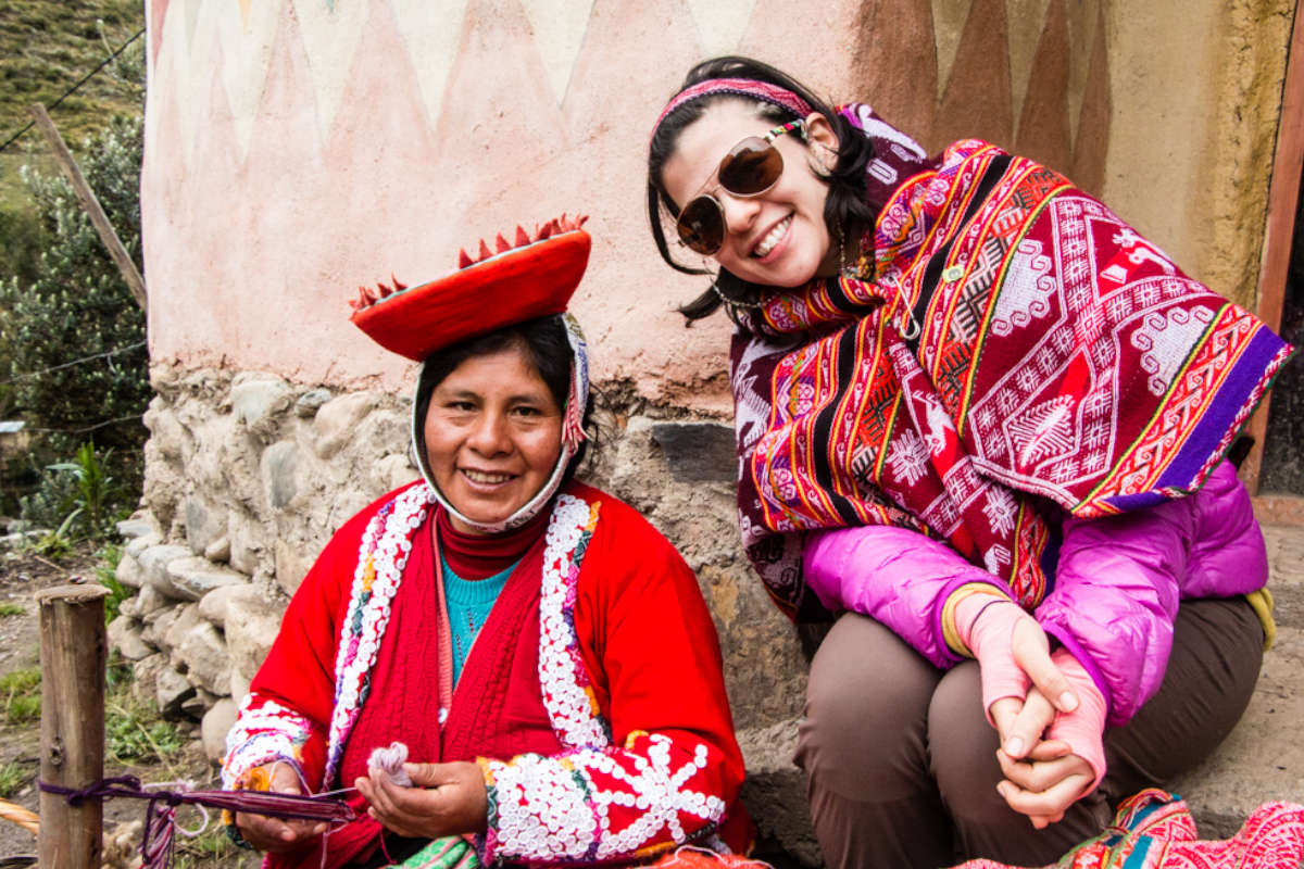 Volunteer with an indigenous Andean woman artisan as part of a program making traditional textiles.