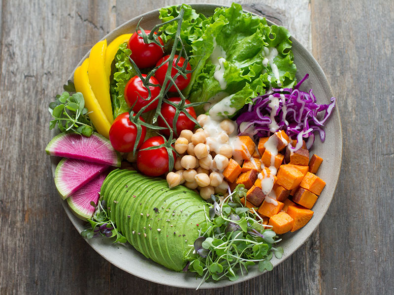 A vegetarian salad with lettuce, chickpeas, sprouts, avocado, cherry tomatoes and other ingredients.