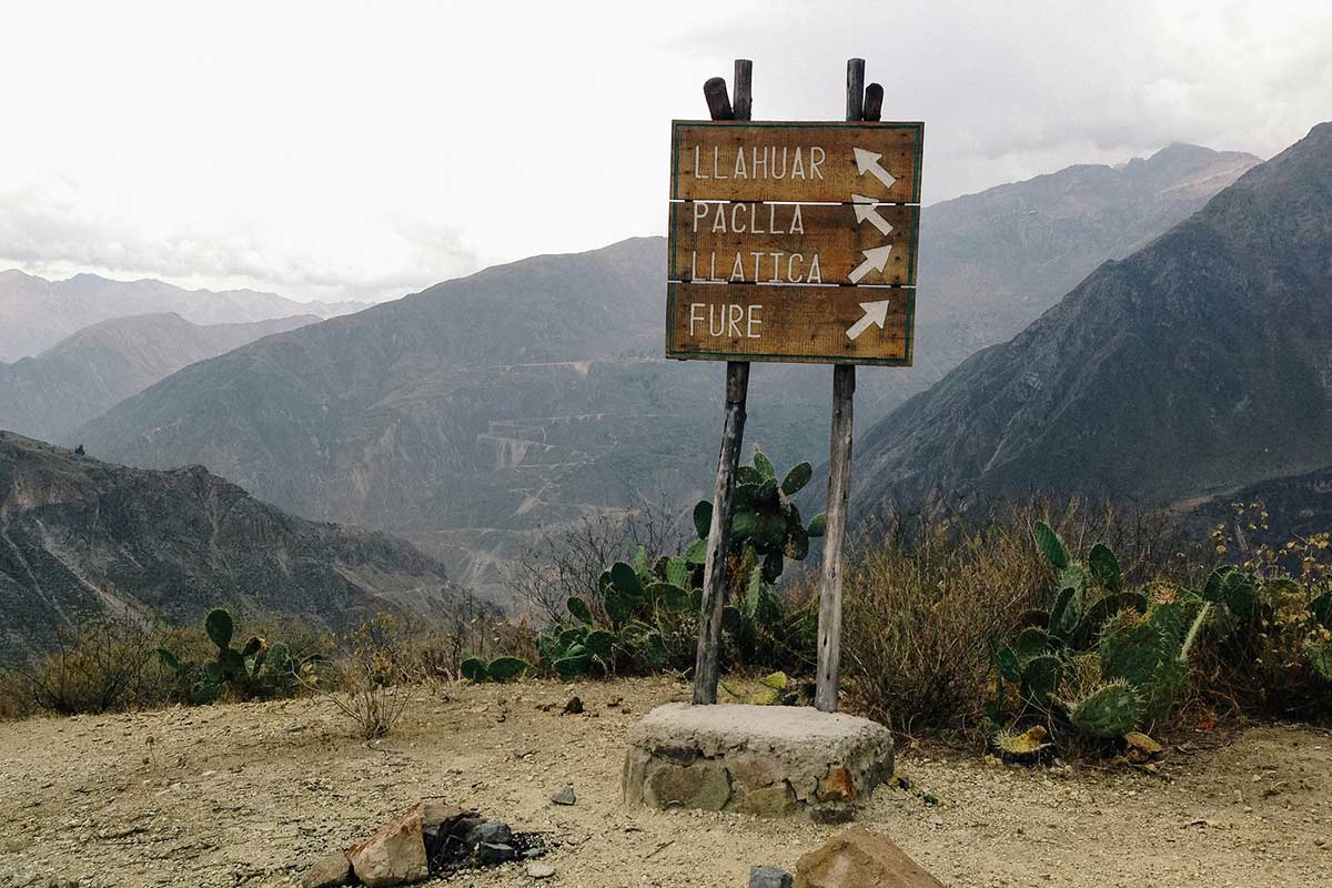 Wooden sign pointing to Llahuar and other Colca Canyon villages.