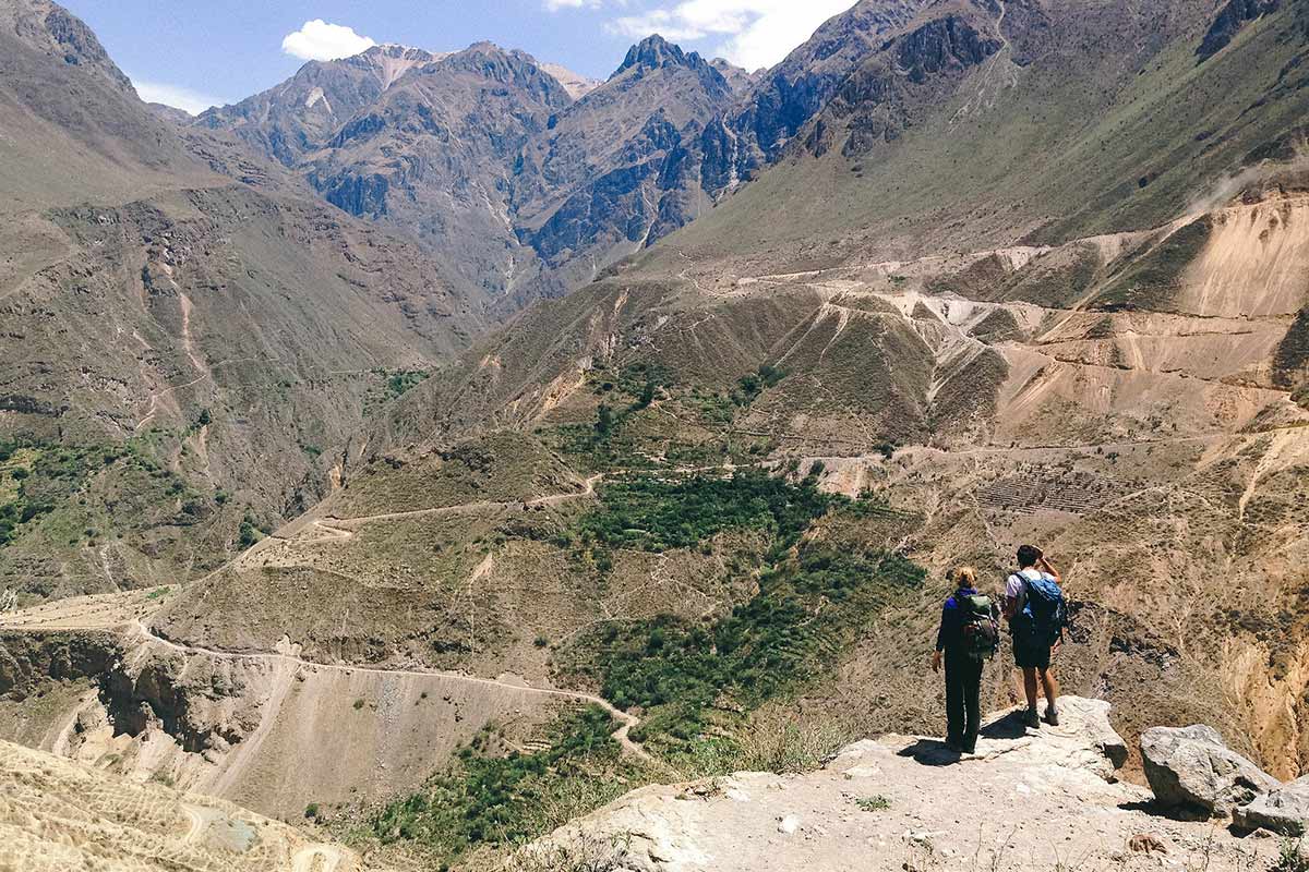 Two trekkers looking over switchback trails in Colca Canyon.