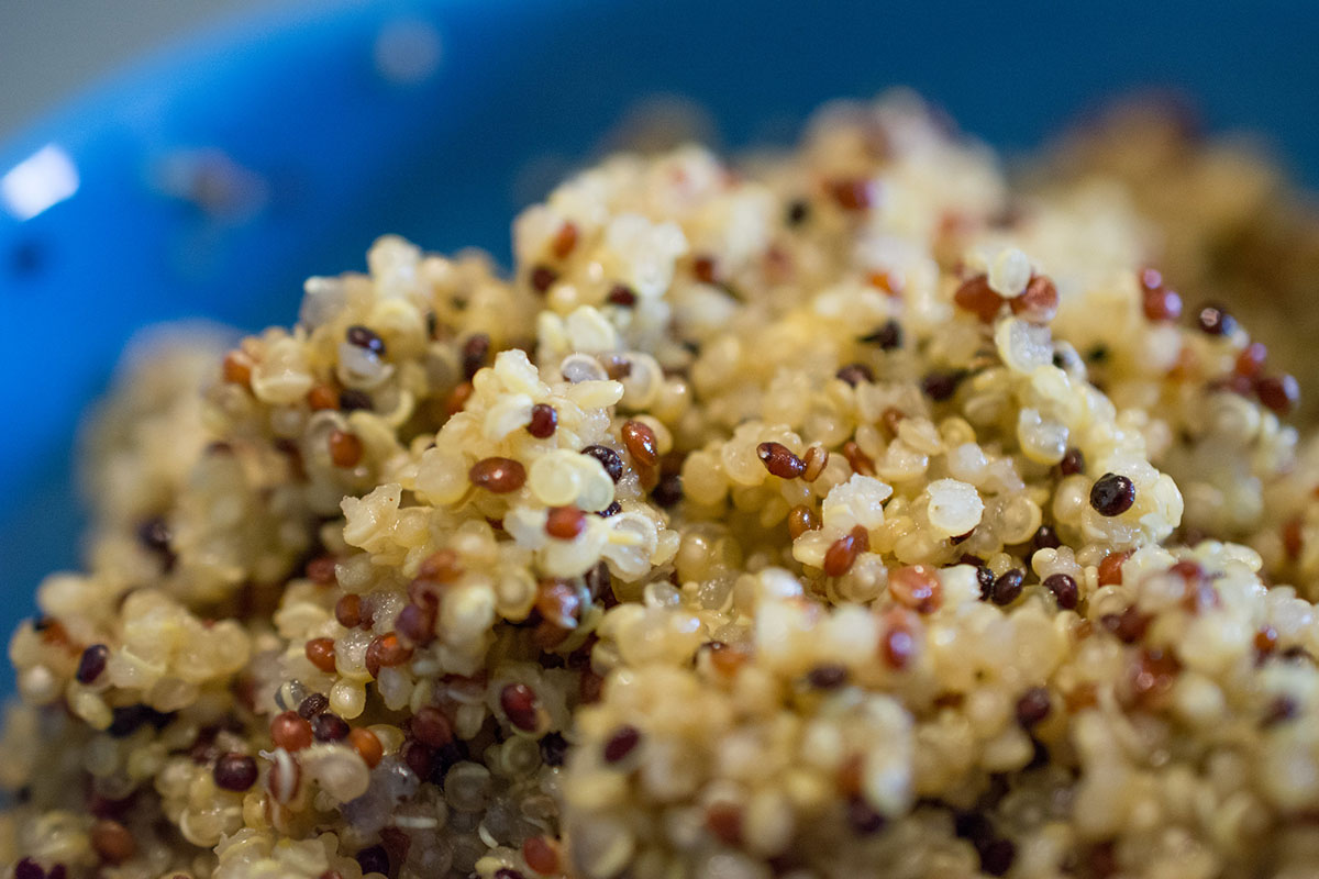 Fluffy cooked white and red quinoa in a blue bowl.