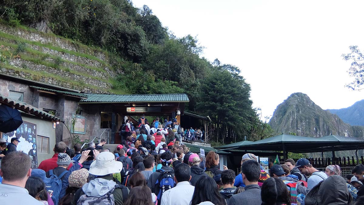 Packed lines of visitors waiting at the entrance of Machu Picchu.