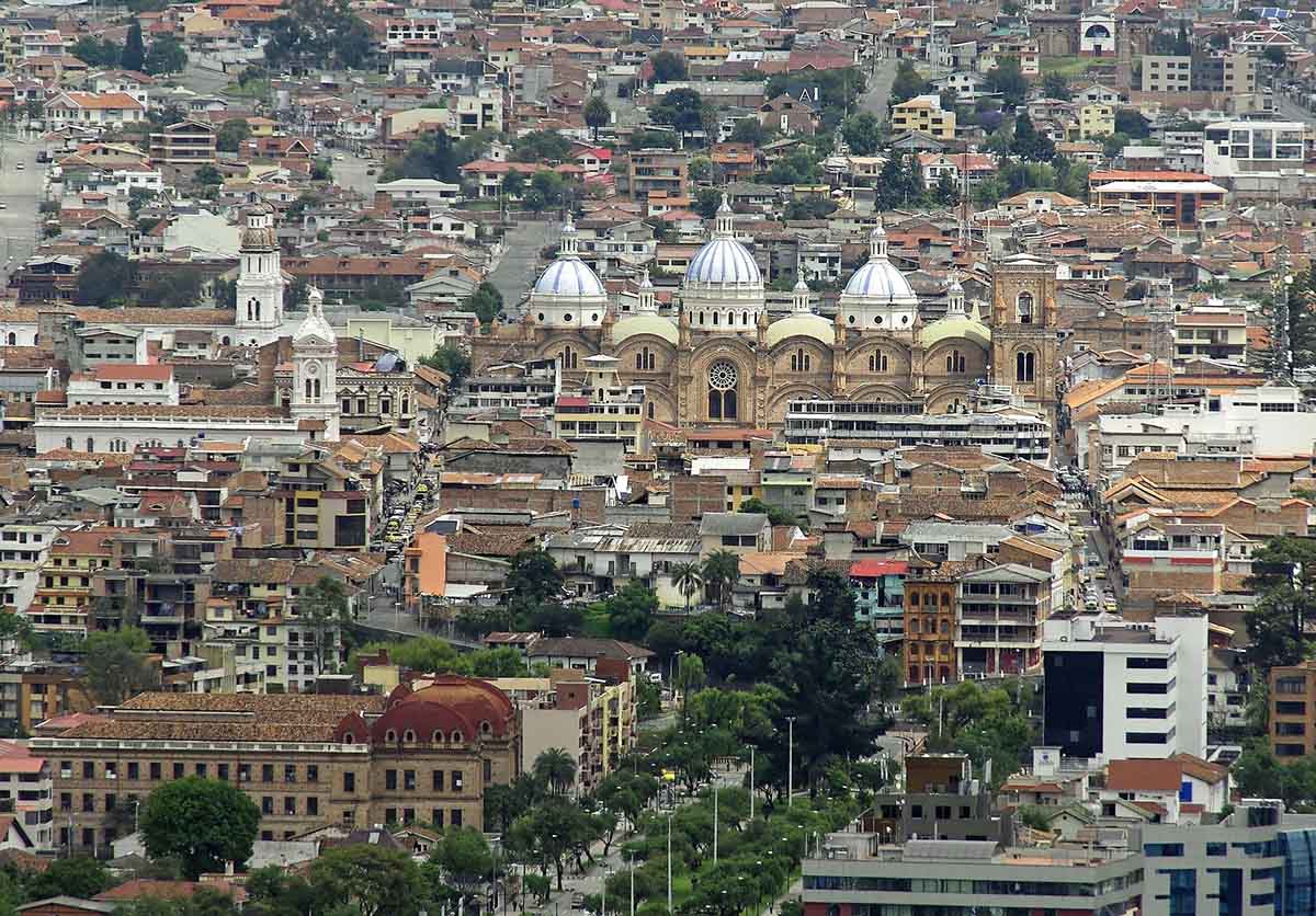 The Cuenca Cathedral with three blue domes is surrounded by a rather dense cityscape.