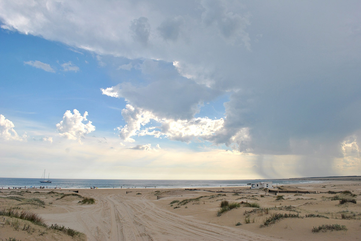 White sandy beach leads to the ocean under cloudy skies in Cabo Polonio, Uruguay.