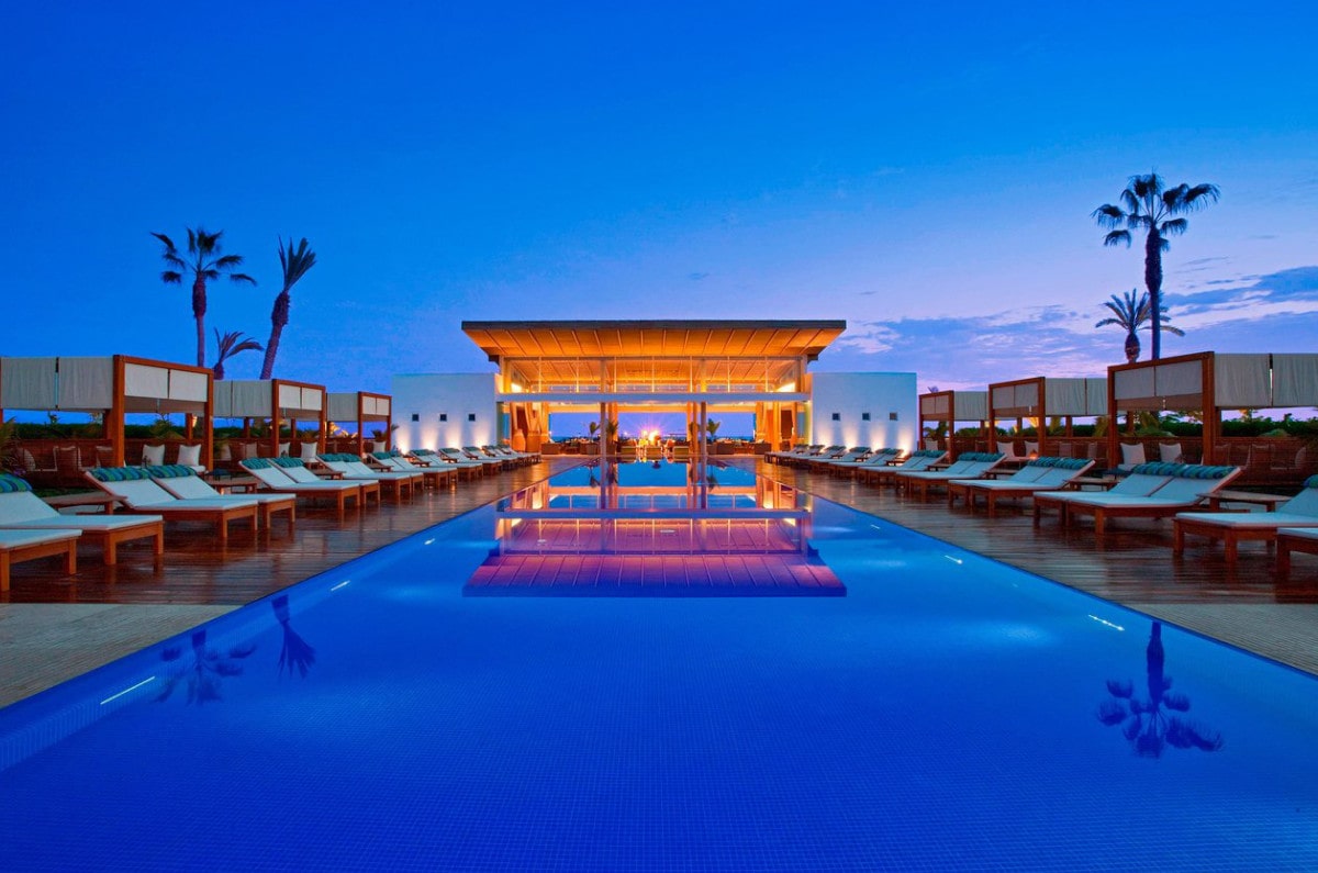 Pool lit at dusk at Paracas Hotel waterfront spa resort in Peru.