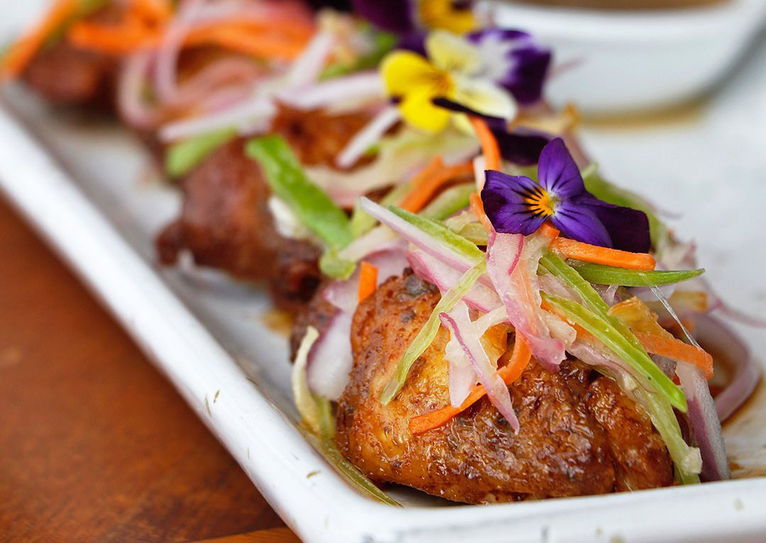 Pieces of meat topped with flowers and small slices of vegetables at the Huaca Pucllana.