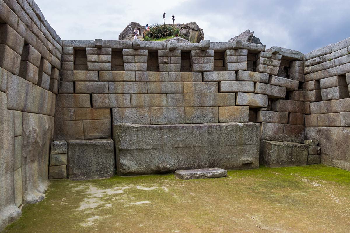 A view of Inca stonework in Machu Picchu on a cloudy day.