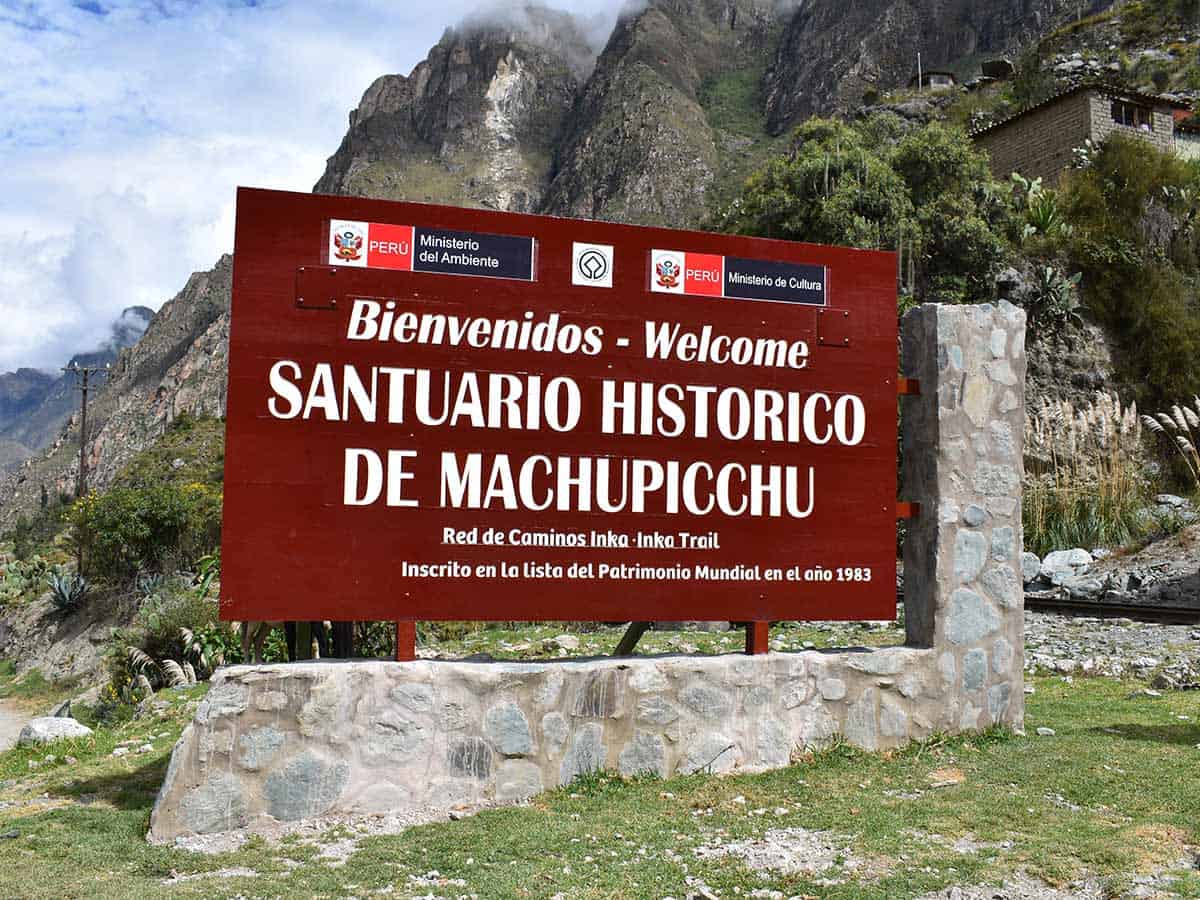 red welcome sign for the Machu Picchu Sanctuary at the start of the Inca Trail