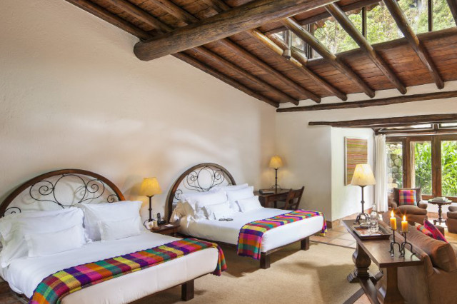 Inkaterra el Pueblo guestroom with 2 beds and skylights.