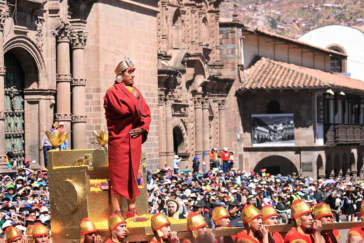 A man standing on a raised, golden throne for the Inti Raymi celebration in Cusco.