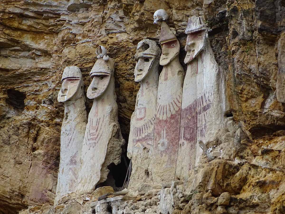 Five sarcophagi with human features embedded in a rocky cliff at Karajia.