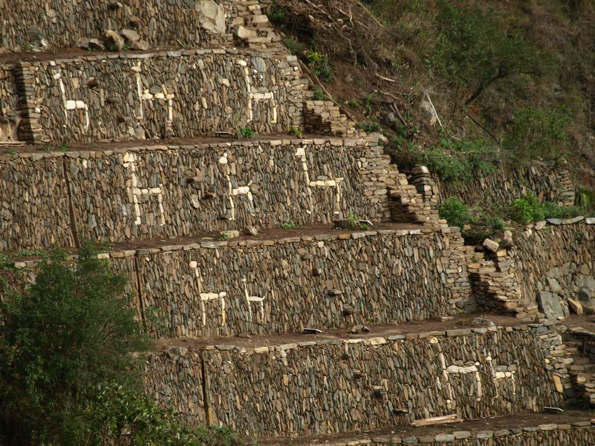 White stones outline the shape of llamas on the side of several Inca terraces at Choquequirao.