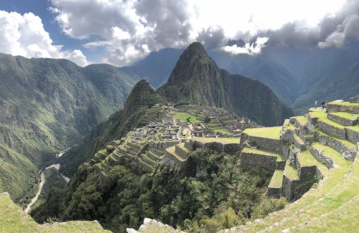 Clouds hover over the stone and grass terraces at Machu Picchu once used for agriculture