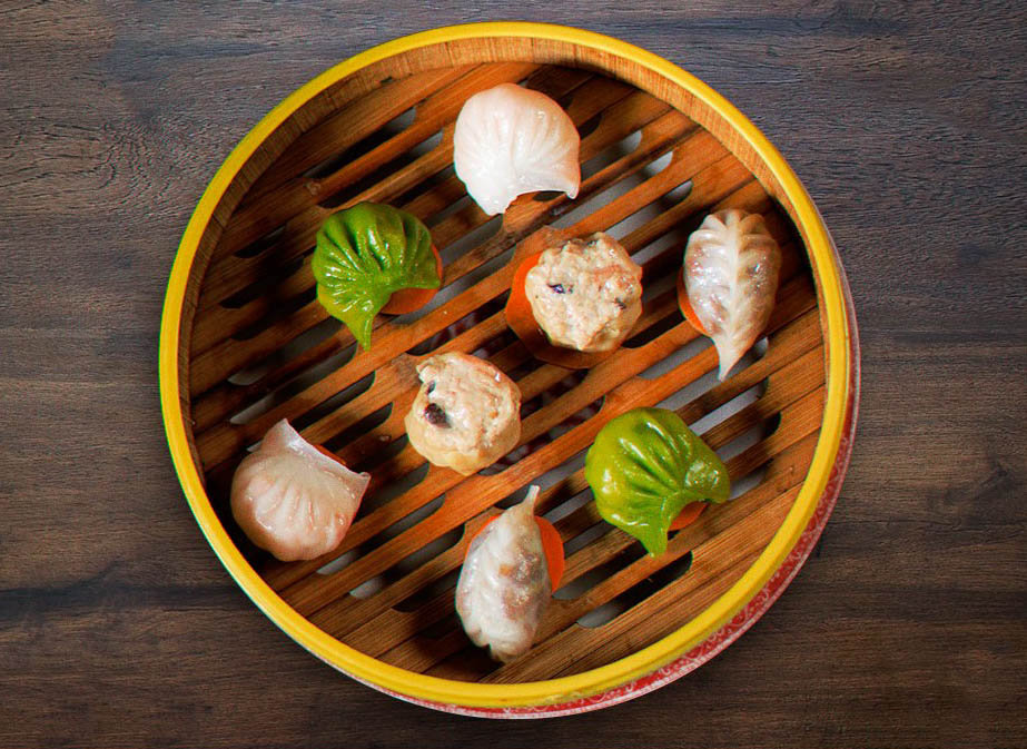 A wooden basket with eight pieces of dim sum, Chinese small bites, at Madam Tusan in Lima.
