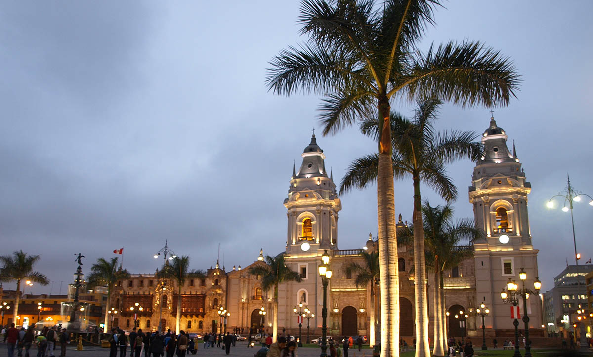 The Lima Cathedral's façade illuminated in yellow light in the historic downtown center of Lima