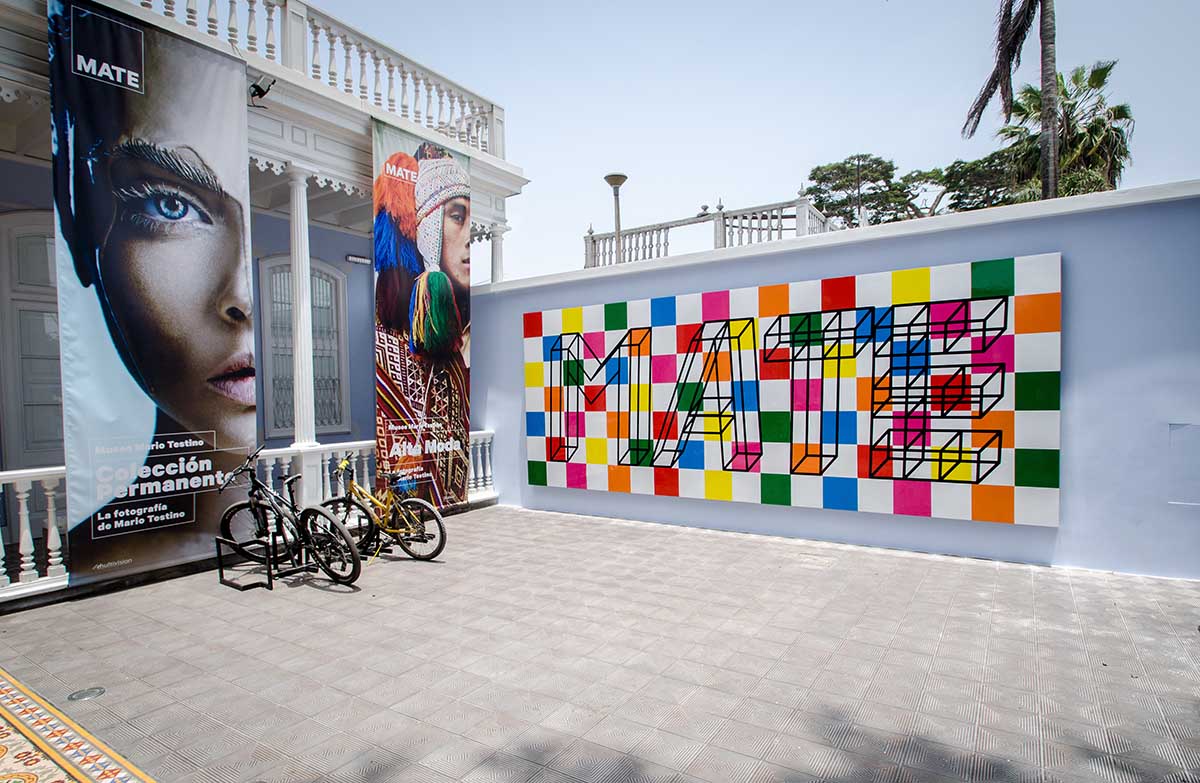 MATE museum logo on a colorful checkerboard and large posters of Testino's photos at the entrance.