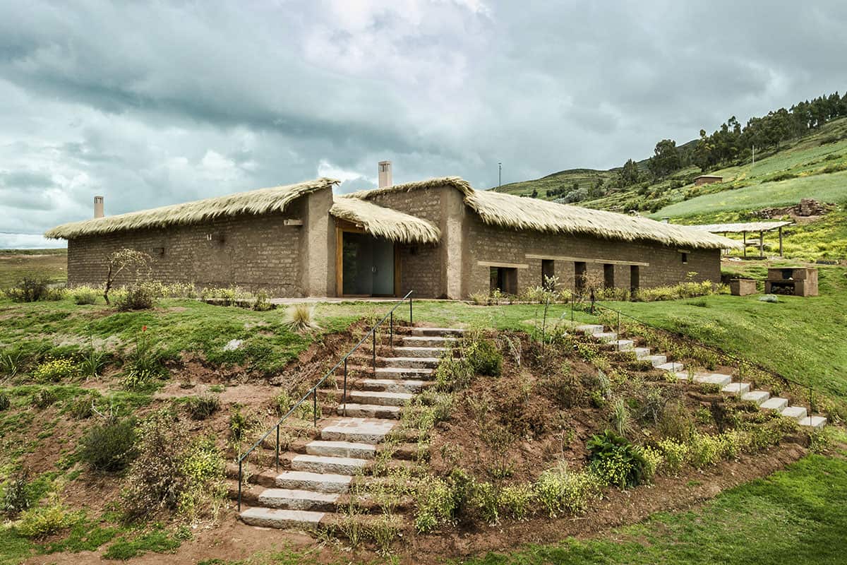 stone steps and terraced gardens lead to the brown brick building of MIL restaurant in Peru.