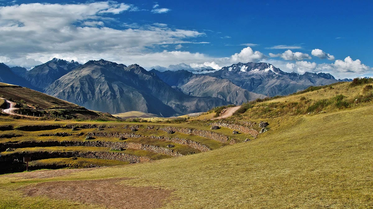 The concave terraces of the Moray ruins are surrounded by the Andes mountains
