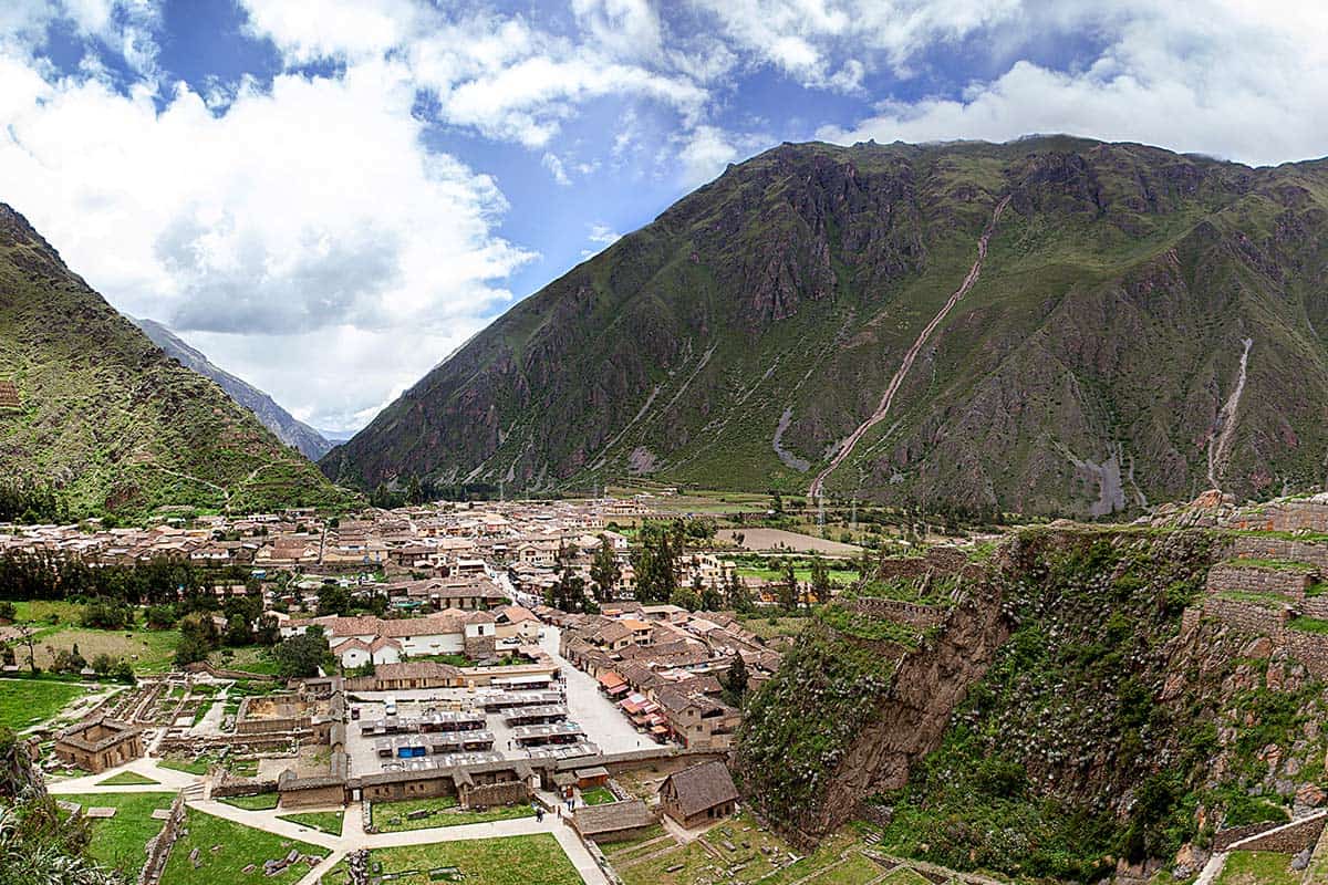 The small town of Ollantaytambo in the Sacred Valley surrounded by tall green mountains.