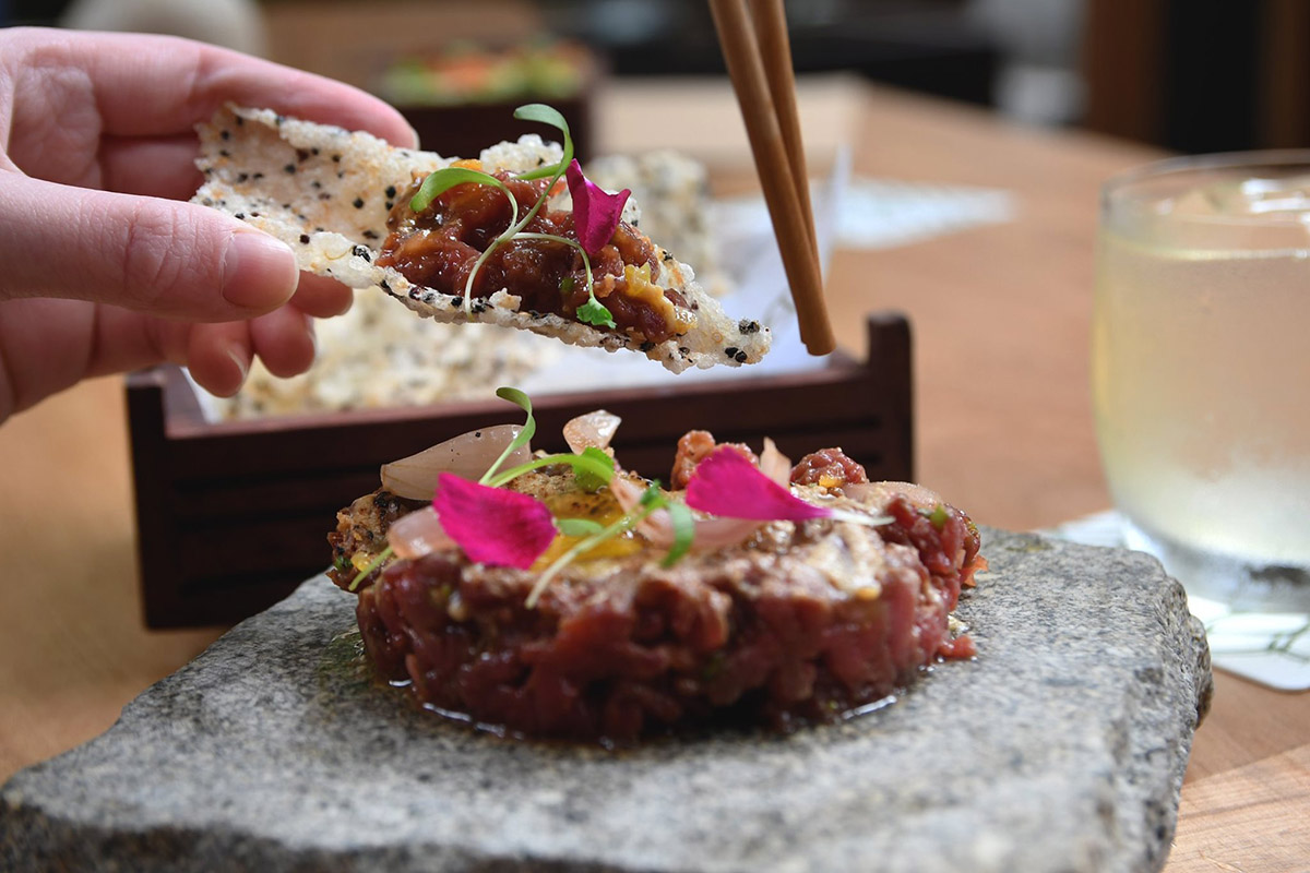 A Nikkei dish at Osaka in Lima, served on a stone with chopsticks.