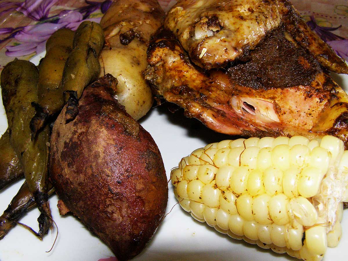 A plate full of various meats and vegetables, typical of a pachamanca meal.