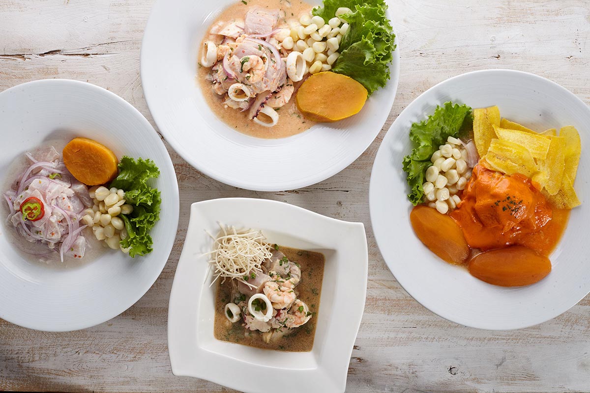 Four white dishes with different types of ceviche in each at Punto Azul, a top restaurant in Lima.
