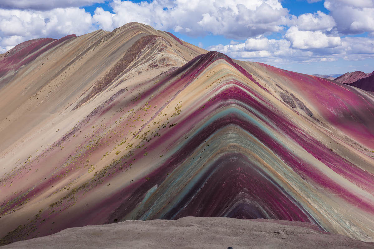 Rainbow Mountain with a partially cloudy sky in Peru.