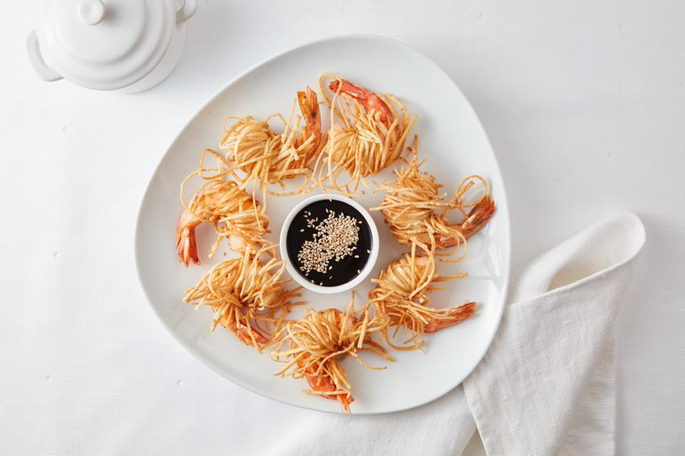 Seven fried shrimp surround a brown sauce at La Rosa Nautica in Lima.
