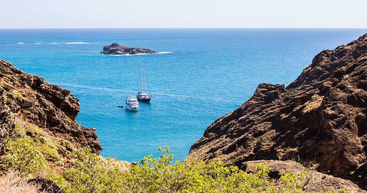 Ships cross crystal blue waters to Punta Pitt on the northeast coast of San Cristobal Island.