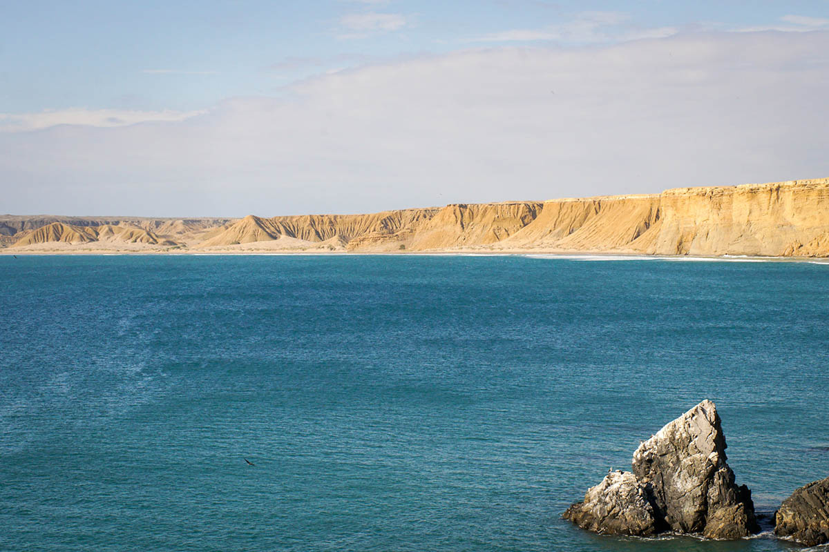 Blue ocean leading to sandy cliffs of the Sechura Desert in South America.