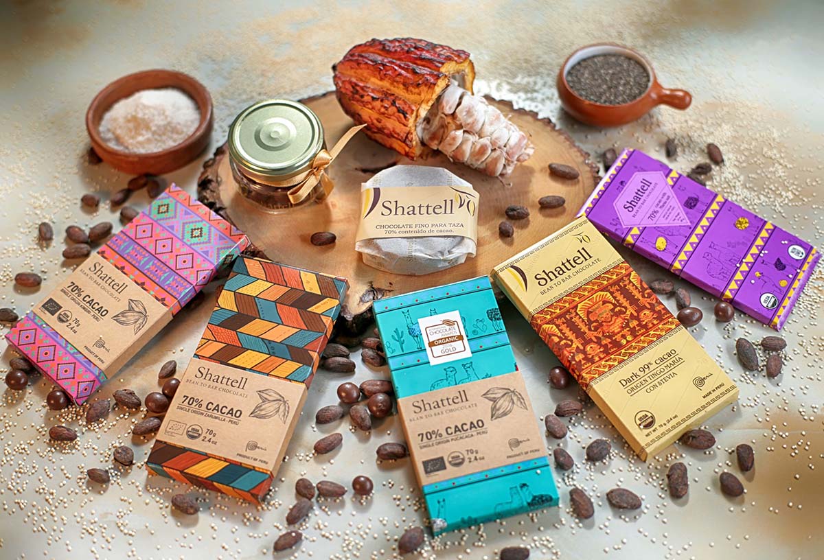 Shattell chocolate bars on a table with cacao beans, quinoa and salt — ingredients added to the bars