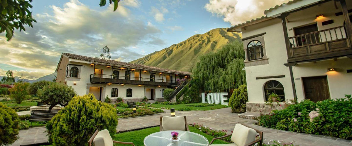 Gardens of Sonesta Posada Hotel in the Sacred Valley with green mountains in the distance