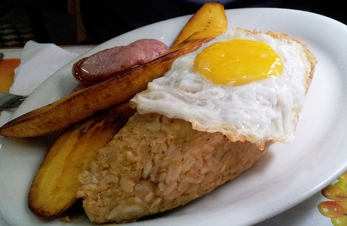 Tacu tacu, a traditional dish with rice and beans, typically comes with an egg and fried bananas.