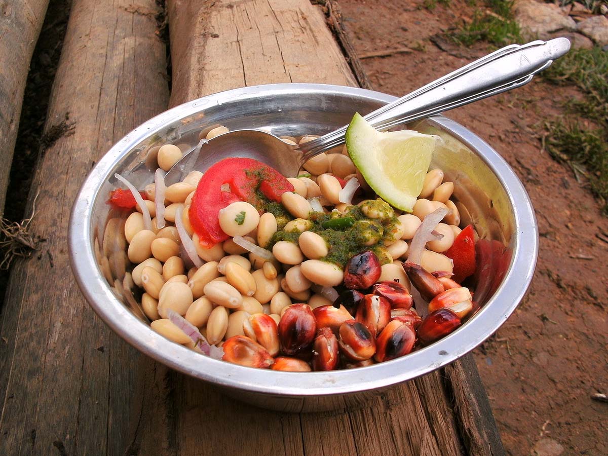 A bowl of Tarwi, a protein-dense Peruvian superfood, prepared with tomato, lime, corn and tomato