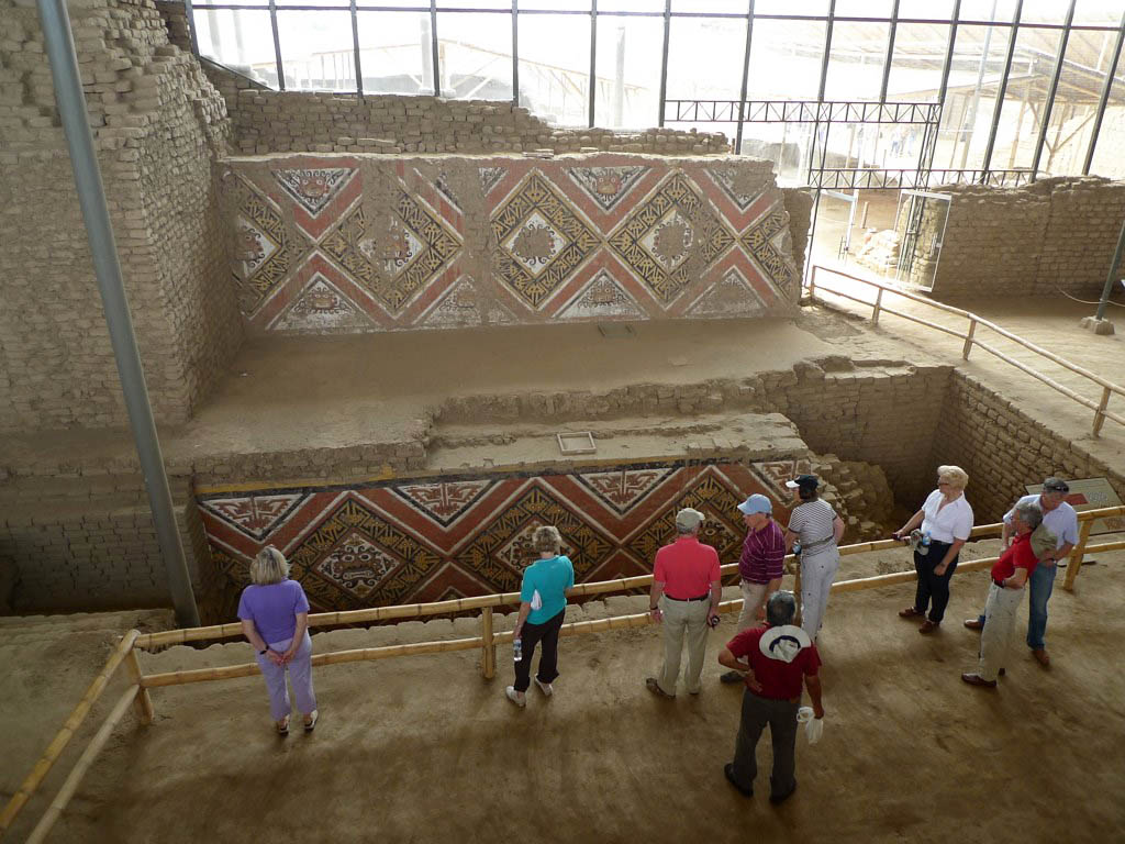 Nine visitors overlook the intricate murals of the Moche Temple of the Moon.